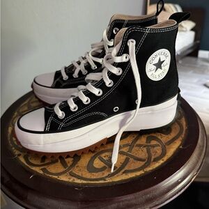 Chuck’s. Black high tops converse. W tan grip on bottom